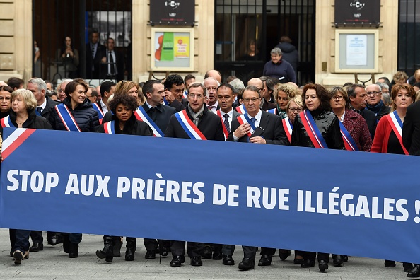 Rassemblés derrière une banderole proclamant "Stop aux prières de rue illégales", le maire de Clichy Rémi Muzeau, ainsi que d’autres maires, parlementaires, conseillers municipaux et régionaux LR, UDI (centre-droit) et MoDem (centre), venus pour beaucoup de région parisienne, sont allés au devant de quelque 200 fidèles rassemblés dans une rue piétonne pour la prière le 10 nobembre 2017. (ALAIN JOCARD/AFP/Getty Images)