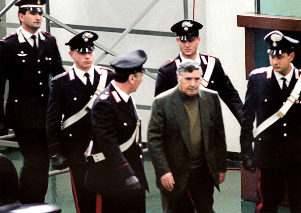 Une photo prise le 8 mars 1993 montre le patron de la mafia, Salvatore 'Toto' Riina, lors de son procès à la prison de haute sécurité Ucciardone à Palerme. L'ancien patron des patrons, Toto Riina, l'un des parrains les plus redoutés de l'histoire de la mafia sicilienne, est décédé tôt le 17 novembre 2017 après avoir lutté contre le cancer, selon les médias italiens. Riina, 87 ans, qui avait purgé 26 peines d'emprisonnement à perpétuité et qui aurait commandité plus de 150 meurtres, était dans le coma et sa famille avait reçu jeudi l'autorisation du ministère italien de la Santé pour une visite exceptionnelle. 
(ALESSANDRO FUCARINI / AFP / Getty Images)      