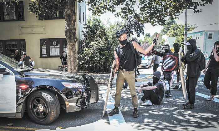 Des extrémistes de gauche Antifa [NDLR : Antifascisme] se préparent à une confrontation avec les forces de l’ordre  à Berkeley, en Californie, le 27 août 2017. La théorie communiste du matérialisme dialectique vise à inciter au conflit et à la lutte. (AMY OSBORNE / AFP / GETTY IMAGES)