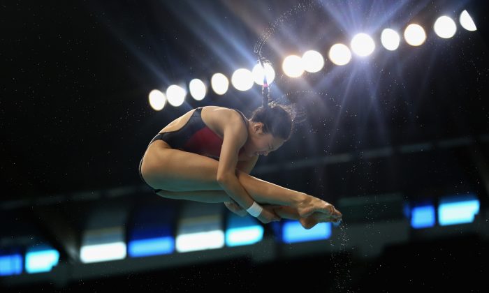 Han Wang effectue un plongeon du tremplin de trois mètres lors de la finale de la complétion de FINA / NVA Diving World Series 2014 dans le complexe sportif de Hamdan à Dubaï, le 21 mars 2014. (Warren Little / Getty Images)
