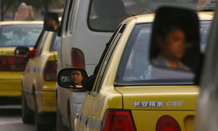 Cette photo, prise le 18 avril 2006, montre une file d'attente à une station-service pour faire le plein en gaz naturel à Chongqing. (China Photos / Getty Images)