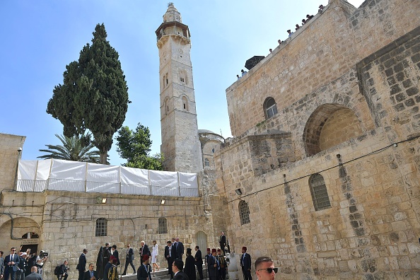 Le président américain Donald Trump (C) et la première dame Melania Trump marchent devant l'église du Saint-Sépulcre dans la vieille ville de Jérusalem le 22 mai 2017. 
(MANDEL NGAN / AFP / Getty Images)