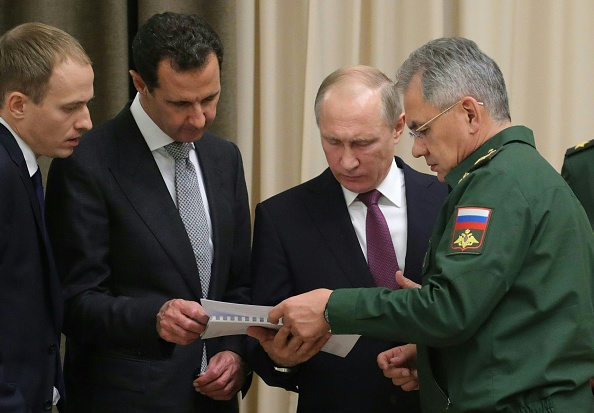 Le président russe Vladimir Poutine  (2e d) accompagné de son ministre de la Défense Sergei Shoigu (d) rencontre son homologue Bachar al-Assad (2e g.) à Sochi le 20 novembre 2017. (MIKHAIL KLIMENTYEV/AFP/Getty Images)