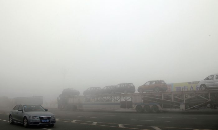 Des voitures arrêtées sur une autoroute à cause d'un dense nuage de pollution dans la province du Jilin, Chine, le 22 octobre 2013. (STR / AFP / Getty Images) 