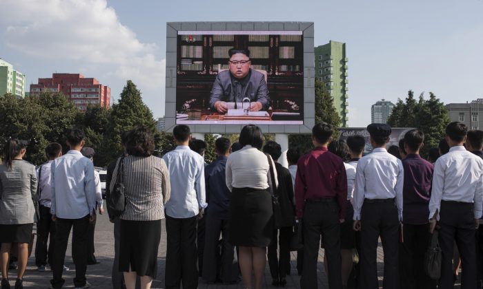 Les Nord-Coréens écoutent la diffusion d’une déclaration du dictateur Kim Jong-Un sur un grand écran de télévision devant la gare de Pyongyang, le 22 septembre 2017. (ED JONES/AFP/Getty Images)