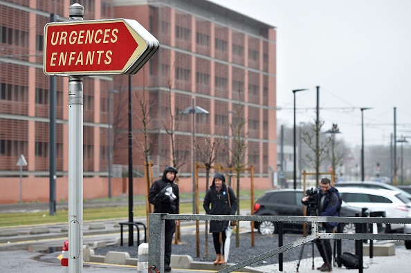 Des journalistes se tiennent près d'un panneau indiquant l'entrée d'urgence de l'hôpital pour enfants Purpan à Toulouse, dans le sud de la France, sur la photo le 6 janvier 2018. Le procureur de Toulouse a alerté le public de l'enlèvement d'un nouveau né de 2 mois par son père. Le bébé nommé Tizio, en réanimation, a été pris le 5 janvier 2018 à l'hôpital Purpan de Toulouse par son père, un homme de 33 ans, selon le parquet. (REMY GABALDA / AFP / Getty Images)