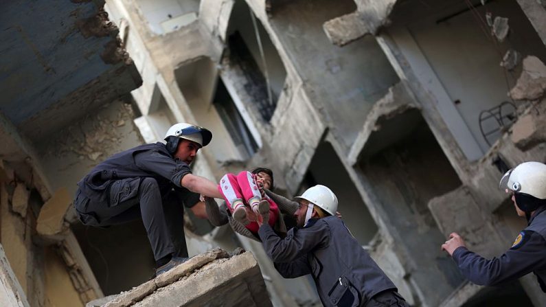 Les membres de la Défense civile syrienne, connus sous le nom de Casques blancs, évacuent un enfant lors d'une séance d'entraînement dans la région de la Ghouta. Photo AMER ALMOHIBANY / AFP / Getty Images.