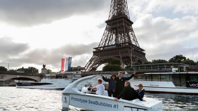 Les co-fondateurs de la compagnie Sea Bubbles suédoise Anders Bringdal et le français Alain Thebault se tiennent avec le maire de Paris, Anne Hidalgo à bord d'un « taxi volant » sur la Seine à Paris. Les ingénieurs aéronautiques et les watermen Anders Bringdal et Alain Thebault sont les développeurs de l'écosystème de transport à impact zéro.       Photo JOEL SAGET/AFP/Getty Images