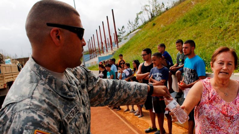 Un soldat de l'armée américaine distribue de l'eau en bouteille aux habitants affectés par le passage de l'ouragan Maria à Barranquitas, PHOTO RICARDO ARDUENGO / AFP / Getty Images.