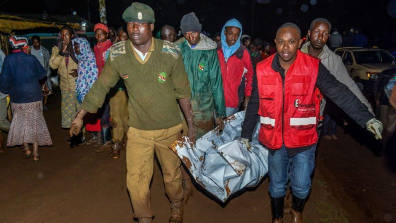 Les gens transportent le corps d'une victime dans une zone résidentielle après que le barrage de Patel a fait irruption à Solai.
Photo  should read /AFP/Getty Images)