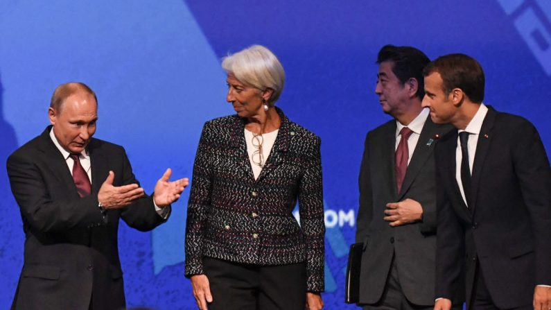 Le président russe Vladimir Poutine, Christine Lagarde, directrice générale du Fonds monétaire international, le Premier ministre japonais Shinzo Abe et le président français Emmanuel Macron assistent à une session du Forum économique international de Saint-Pétersbourg le 25 mai 2018. Photo par Kirill KUDRYAVTSEV /Getty Images.