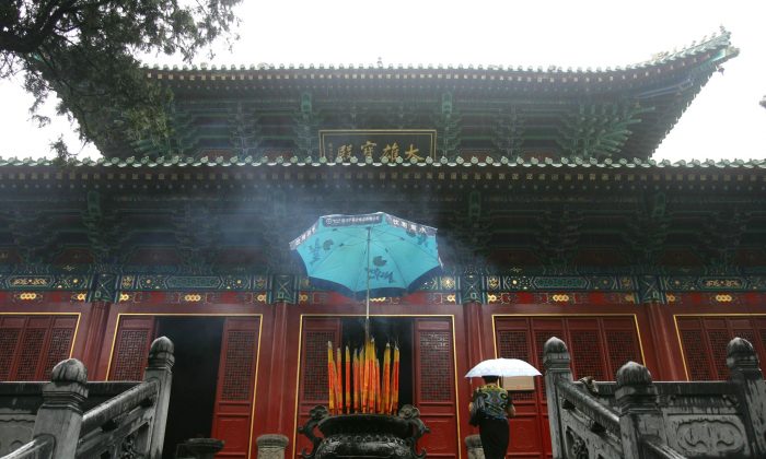 Dengfeng, Chine, une touriste se dirige vers le temple Shaolin à la montagne de Songshan dans la province du Henan le 25 août 2006. Le temple a été construit en l’an 495 et est considéré comme le berceau du Kung Fu de Shaolin. (China Photos/Getty Images) 