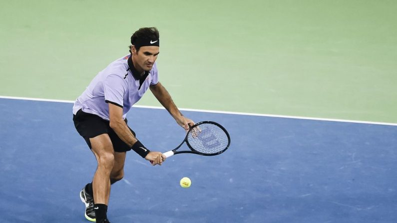 La superstar du tennis suisse Roger Federer remet le ballon au numéro un mondial Andy Murray lors d'un match de charité. Photo MICHAEL BUHOLZER / AFP / Getty Images.