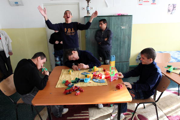 Des adultes roumains handicapés et orphelins jouent à l'orphelinat de Babeni, au sud-ouest de la Roumanie. Vingt ans après la mort de l'ancien dictateur Nicolae Ceausescu, les orphelinats sont encore pleins d'enfants et d'adultes. Photo THOMAS COEX/AFP/Getty Images.