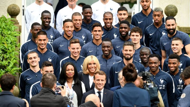 Le président français Emmanuel Macron, son épouse Brigitte Macron et la ministre française des Sports Laura Flessel, posent avec les joueurs de l'équipe nationale de France lors de leur visite des terrains d'entraînement de l'équipe à Clairefontaine-en-Yvelines le 5 juin 2018. Photo : FRANCK FIFE / AFP / Getty Images.