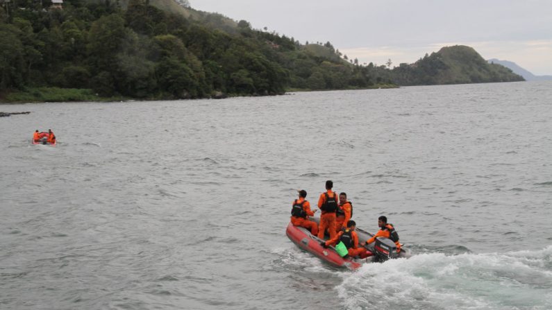 Les équipes de secours continuent à rechercher des victimes sur le lac Toba dans la province de Sumatra du Nord tôt le 19 juin 2018. Photo LAZUARDY FAHMI / AFP / Getty Images.