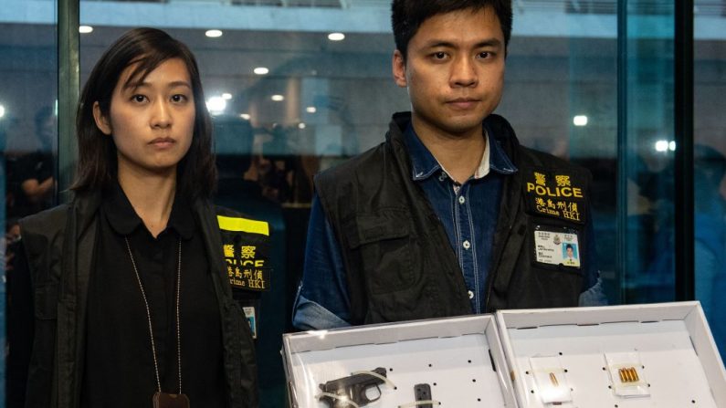 Les policiers ont brandi une arme de poing et des munitions saisies après qu'une femme a blessé quatre personnes dans un parc de Taikoo Shing à Hong Kong le 26 juin 2018. Photo de PHILIP FONG / AFP / Getty Images.