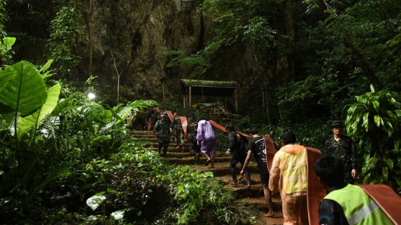   Les sauveteurs thaïlandais portent un tuyau dans la grotte de Tham Luang pour pomper l'eau dans la grotte au parc de Khun Nam Nang à Chiang Rai le 27 juin 2018. Photo LILLIAN SUWANRUMPHA/AFP/Getty Images.