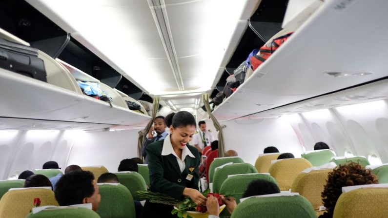 Le 18 juillet 2018. Les passagers sont accueillis par le personnel de cabine avec des fleurs et du champagne, lors du premier vol d'Ethiopian Airlines. Il a quitté l'aéroport international de Bole à Addis-Abeba, en Ethiopie, vers la capitale érythréenne Asmara. Photo MAHEDER HAILESELASSIE TADESE / AFP / Getty Images.