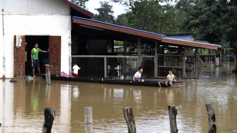 Des enfants jouent sur un bateau devant leur maison inondée à Sanamxai, dans la province d’Attapeu, le 25 juillet 2018. Les sauveteurs ont retrouvé 19 corps et des centaines d’autres sont toujours portés disparus après l’effondrement du barrage. Photo NHAC NGUYEN / AFP / Getty Images.