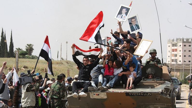 Des drapeaux de l'armée syrienne entrent à Deraa al-Balad et hissent le drapeau national sur la place publique. Photo LOUAI BESHARA / AFP / Getty Images.