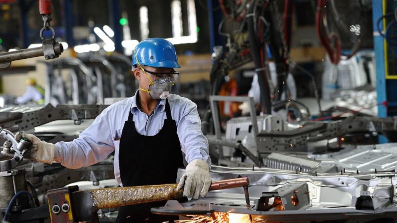   Cette photo montre un travailleur vietnamien soudant dans l'atelier de carrosserie de l'usine automobile Ford de la province de Hai Duong, dans le nord du pays. Le Vietnam possède maintenant l'une des économies à la croissance la plus rapide de l'Asie du Sud-Est, tirée par les exportations de produits fabriqués à bas prix, des chaussures Nike aux téléphones Samsung.   Photo  HOANG DINH NAM/AFP/Getty Images.