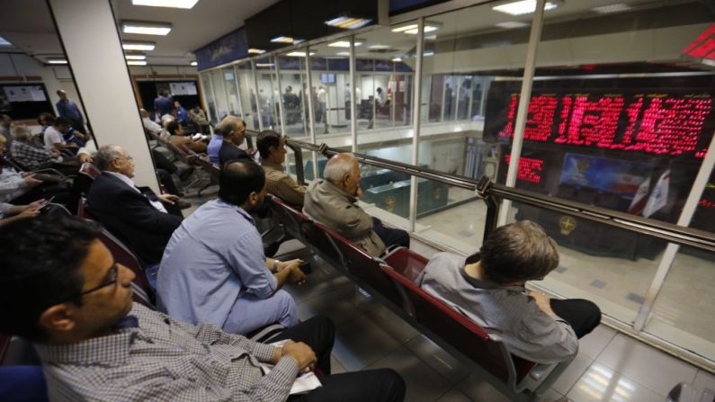 Les hommes iraniens surveillent le marché boursier à Téhéran. Les sanctions nucléaires renouvelées causeraient certainement de graves problèmes à l'économie iranienne. Photo ATTA KENARE / AFP / Getty Images.