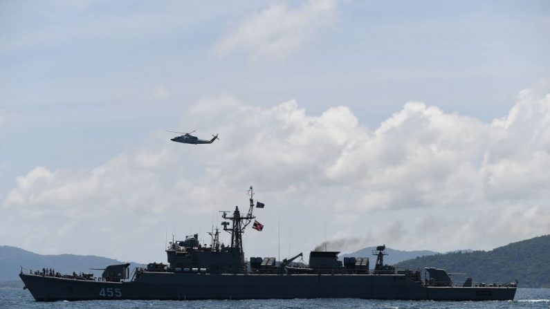 Un hélicoptère et un navire de la marine thaïlandaise fouillent la région près de Phuket le 7 juillet 2018, suite à un accident de bateau survenu le 5 juillet. Photo MOHD RASFAN / AFP / Getty Images.