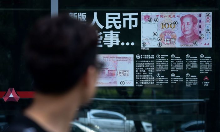 Un homme regarde les informations sur les devises affichées sur la vitre d'une banque à Pékin, le 20 juillet 2018. (Wang Zhao/AFP/Getty Images)