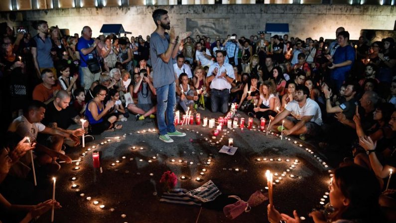 Les gens assistent à une veillée aux chandelles devant le parlement grec à Athènes le 30 juillet 2018. Photo LOUISA GOULIAMAKI / AFP / Getty Images.