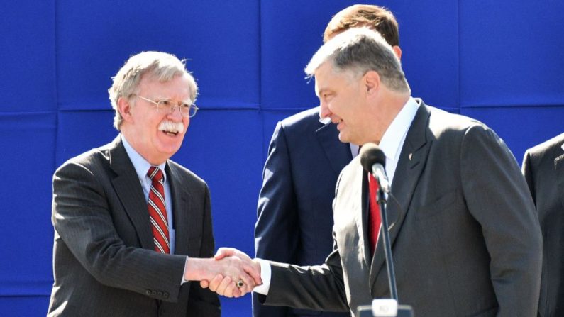 Le président ukrainien Petro Poroshenko donne la main au conseiller américain à la sécurité nationale John Bolton (lors d’un défilé militaire à Kiev le 24 août 2018 pour célébrer le jour de l’indépendance. Photo GENYA SAVILOV / AFP / Getty Images.