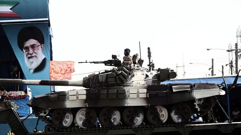 Un soldat iranien assis sur un char T-72 devant le portrait du leader suprême iranien, Ali Khamenei, lors du défilé de la fête de l’armée à Téhéran. Photo : BEHROUZ MEHRI / AFP / Getty Images.