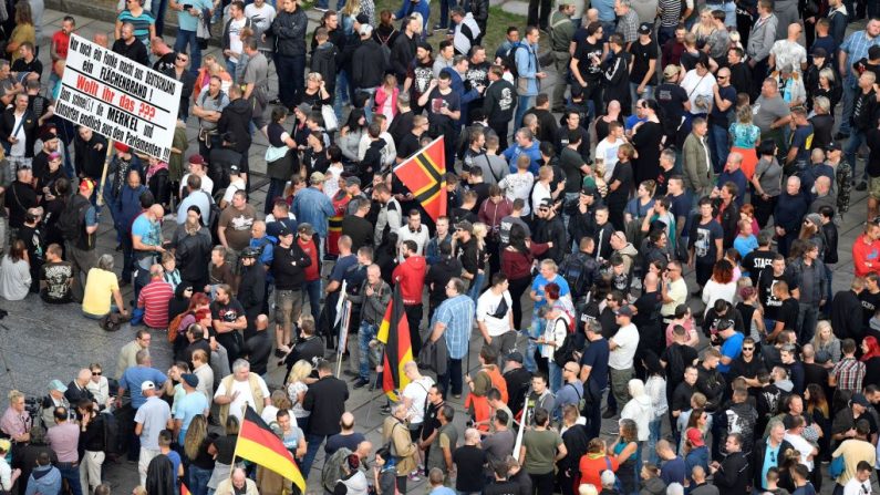 Des manifestants ont brandi des drapeaux et des pancartes lors d’une marche organisée suite au décès d’un jeune homme. Photo JOHN MACDOUGALL / AFP / Getty Images. 