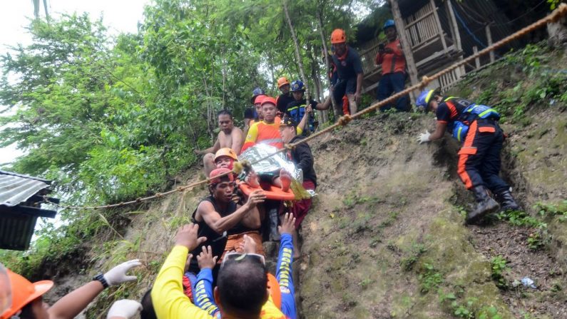 Les secouristes transportent un résident sauvé du site de glissement de terrain de la ville de Naga, sur l'île touristique populaire de Cebu, le 20 septembre 2018. Photo ALAN TANGCAWAN / AFP / Getty Images.