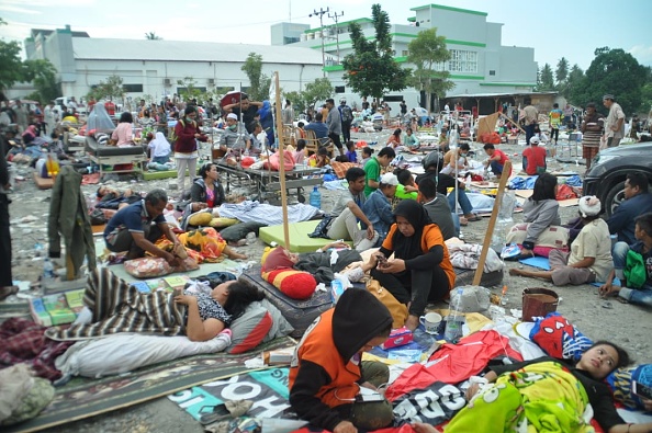 -L'équipe médicale aident des patients à l'extérieur d'un hôpital après le tremblement de terre et le tsunami à Palu, sur l'île de Sulawesi, le 29 septembre 2018. Les secouristes ont envoyé les habitants fuyant leurs maisons vers les hauteurs. Photo MUHAMMAD RIFKI / AFP / Getty Images.