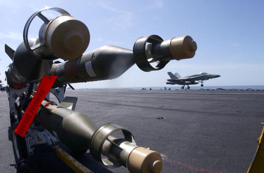 Des bombes guidées au laser de cinq cents livres sont prêtes sur le pont d'envol. Photo de Jayme Pastoric / US Navy / Getty Images.