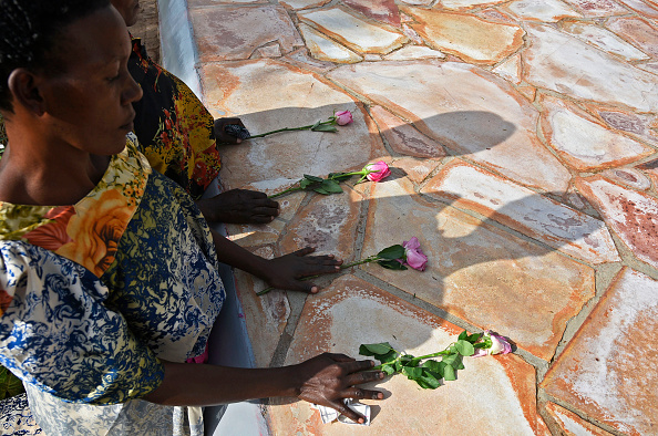 Des réfugiés rwandais déposent des fleurs sur le site commémoratif du génocide de Kasensero, dans le district de Rakai, le 21 avril 2018, lors de la 24ème commémoration du génocide de 1994 contre les Tutsis au Rwanda.  (Photo : ISAAC KASAMANI/AFP/Getty Images)