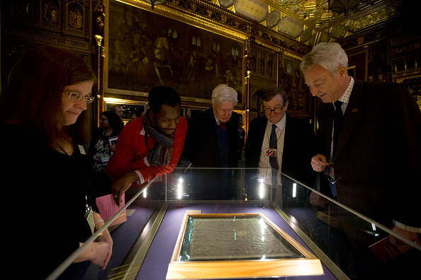 -A Londres, Royaume-Uni des gens, y compris Emily Naish archiviste de la cathédrale de Salisbury, à gauche, regarde la copie de la cathédrale de Salisbury de la Magna Carta comme il est affiché avec les trois autres gravures parchemin originales survivantes de la Magna Carta pour marquer le 800e anniversaire du scellement de la Magna Carta à Runnymede en 1215.