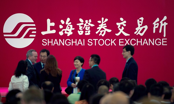 -Des gens se tiennent sur la salle des marchés de la Bourse de Shanghai dans le quartier financier de Lujiazui à Shanghai. Photo JOHANNES EISELE / AFP / Getty Images.