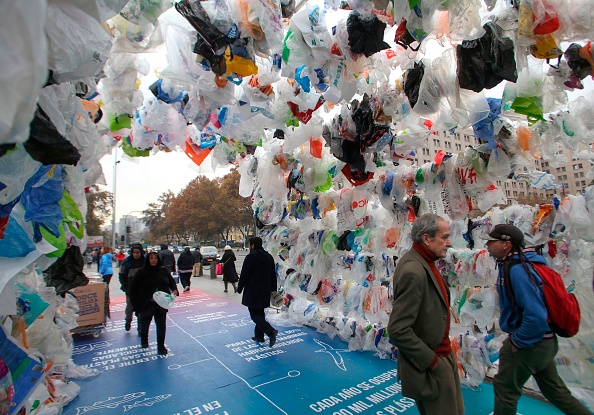 -Des personnes marchent dans un tunnel construit à partir de sacs en plastique devant le palais présidentiel La Moneda à Santiago, à l'occasion de la Journée mondiale de l'environnement le 5 juin 2018. Photo de CLAUDIO REYES / AFP / Getty Images