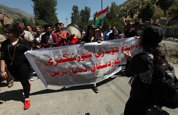 -Des Kurdes irakiens agitent des drapeaux kurdes lors d'une manifestation pour protester contre une opération militaire menée par l'armée turque contre le Parti des travailleurs du Kurdistan (PKK) dans la montagne Qandil, le quartier général du PKK dans le nord de l'Irak, le 22 juin 2018. Photo SAFIN HAMED / AFP / Getty Images.