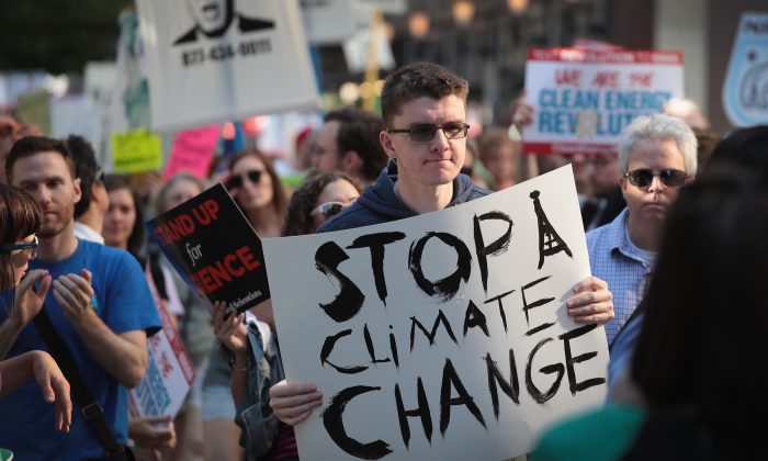 Les manifestants protestent contre la décision du président Donald Trump de mettre fin à l'accord de Paris sur les changements climatiques le 2 juin 2017 à Chicago, Illinois. Les manifestants prétendent que leur but est de protéger l'environnement. Cependant, les moyens d'atteindre les objectifs déclarés des Nations Unies ou de l'Accord de Paris sur le changement climatique trahissent leur programme socialiste. (Scott Olson/Getty Images)