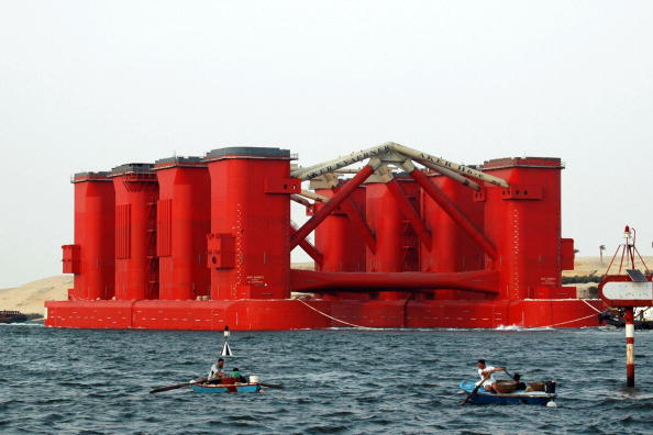 -Des pêcheurs égyptiens naviguent à proximité de la plus grande plate-forme de forage au monde, qui transite par le canal de Suez, près de la ville d'Ismaïlia. La plate-forme de forage H-6e est la plate-forme semi-submersible la plus avancée utilisée pour forer du pétrole à des profondeurs allant jusqu'à 3 000 mètres avec une longueur de forage maximale de 10 000 mètres. AFP PHOTO / STR / Getty Images.