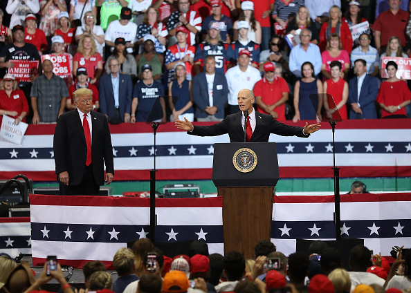 -Le président Donald Trump écoute le gouverneur de la Floride et candidat républicain au Sénat républicain, Rick Scott, s'exprimant lors d'une manifestation à la Hertz Arena le 31 octobre 2018 à Estero, en Floride. Photo par Joe Raedle / Getty Images.