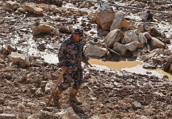 -Un membre d'une équipe de secours jordanienne à la recherche de personnes disparues à la suite d'inondations soudaines dans la ville de Madaba, près de la capitale Amman, le 10 novembre 2018. Des inondations soudaines ont tué 11 personnes en Jordanie et contraint près de 4 000 touristes à fuir la célèbre ville du désert Petra. Photo KHALIL MAZRAAWI / AFP / Getty Images.