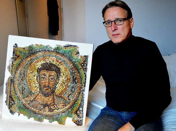 -Le détective artistique néerlandais Arthur Brand pose le 17 novembre 2018, dans une chambre d'hôtel à La Haye, avec la mosaïque manquante de Saint-Marc, une œuvre d'art byzantine volée. Photo JAN HENNOP / AFP / Getty Images.