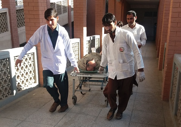 -Des ambulanciers pakistanais transportent une victime blessée après l'attentat à la bombe contre un marché de Kohat, le 23 novembre 2018. Photo BASIT SHAH / AFP / Getty Images.