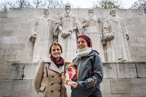 -Les professeurs de théologie genevoise Elisabeth Parmentier et Lauriane Savoy posent sous le mur de la réforme avec une édition de « Une Bible des femmes » le 20 novembre 2018 à Genève. Fatigués de voir les textes sacrés utilisés pour justifier l'assujettissement des femmes, un groupe de théologiennes féministes de la division protestanto-catholique s'est uni pour créer cette Bible. Photo FABRICE COFFRINI / AFP / Getty Images.