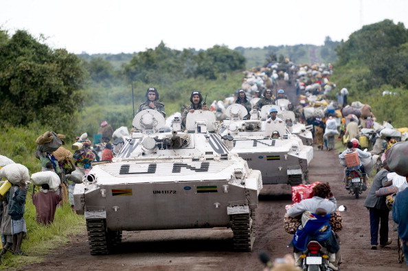 -Des véhicules blindés de l'ONU passent entre le camp de personnes déplacées internes de Kibumba. Depuis octobre 2014, les rebelles ADF sont tenus responsables du massacre de plusieurs centaines de civils et de 15 Casques bleus tanzaniens. Photo WALTER ASTRADA / AFP / Getty Images.