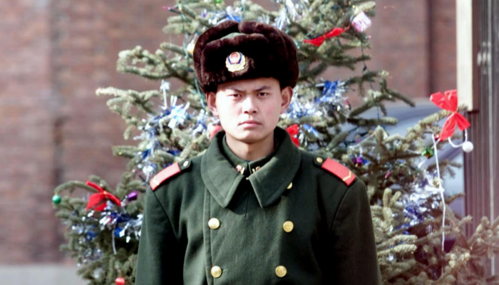 Un policier chinois de la Police armée du people monte la garde devant un arbre de Noël en face du complexe diplomatique à Pékin, le 21 décembre 2000. (Goh Chai Hin/AFP/Getty Images)